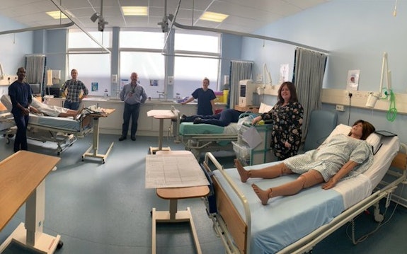 员工 at the School of Healthcare Sciences in a hospital training suite using a dummy to offer training and a skills refresh to staff returning to the NHS.