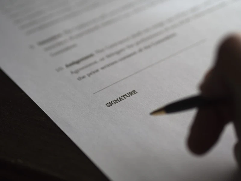 a hand about to sign a contract
