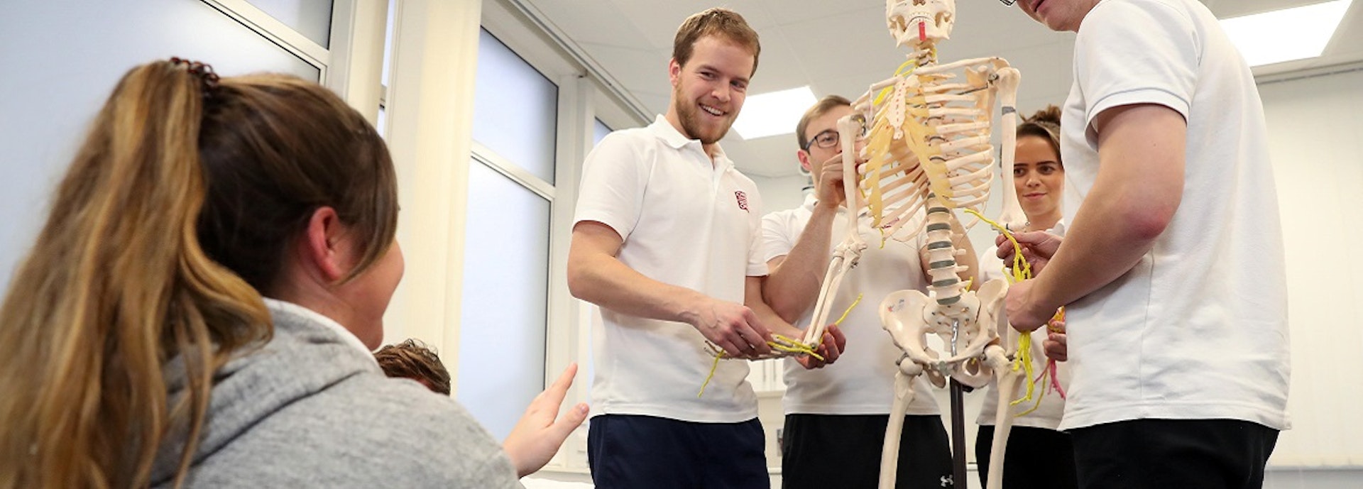 Physiotherapy students with skeleton model