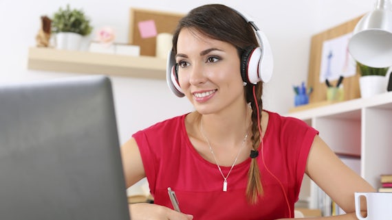 Woman at computer wearing headphones
