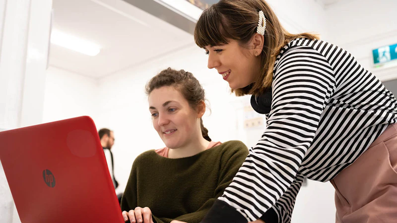 Students look at a laptop
