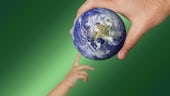 Image of a parent's hand passing the globe to an infant's hand