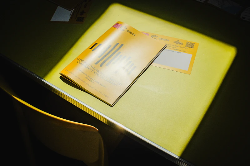 The Community Voices Cardiff report sits in a patch of sunshine on a yellow table.