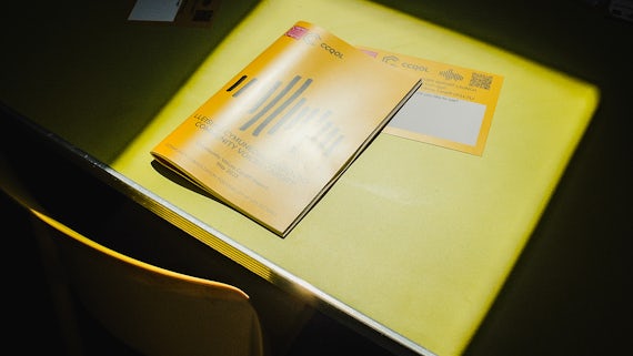 The Community Voices Cardiff report sits in a patch of sunshine on a yellow table.