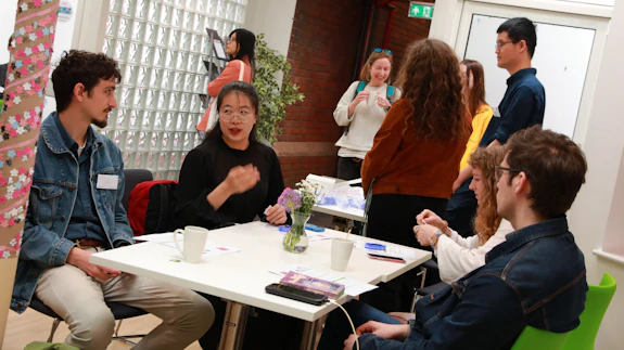 A group of people sitting around a table chatting.