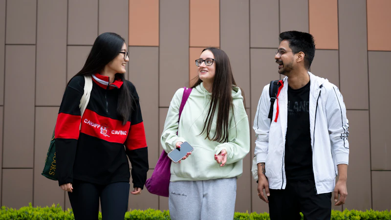 3 students walking together and smiling