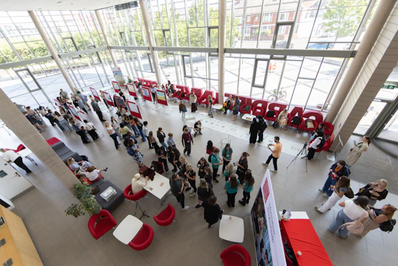 A photo taken of the event from above, showing the students and staff interacting with the posters and activties