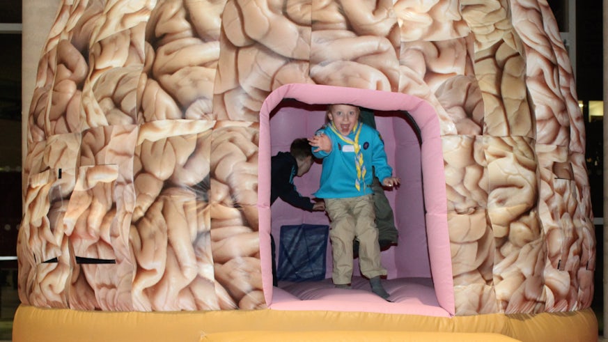 Photograph of child in giant brain dome