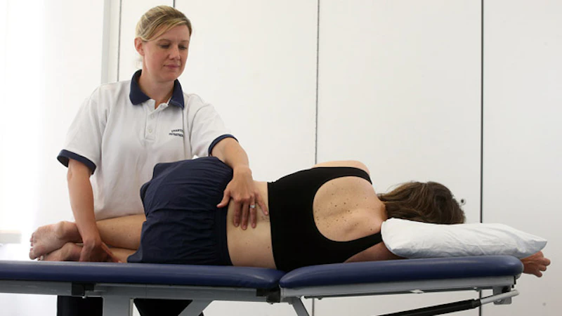 Physiotherapy student learning to apply techniques to a patient.