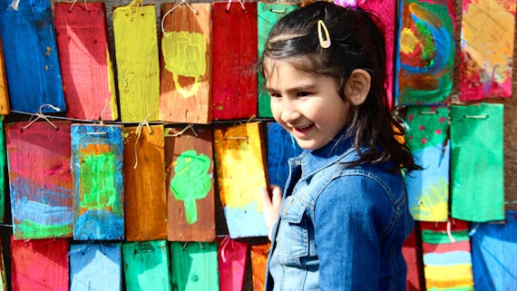 Young girl in front of colourful mural 