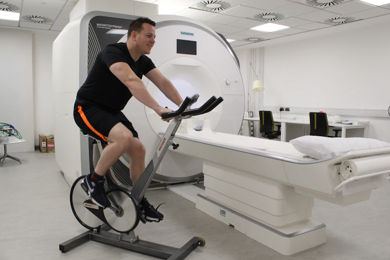 Photograph of a man on an exercise bike in front of an MRI scanner