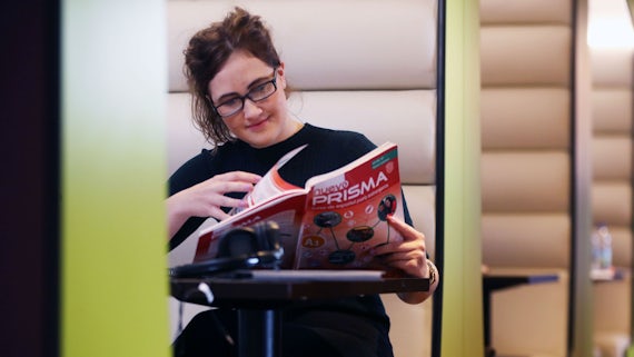 Woman wearing glasses looking at a brochure