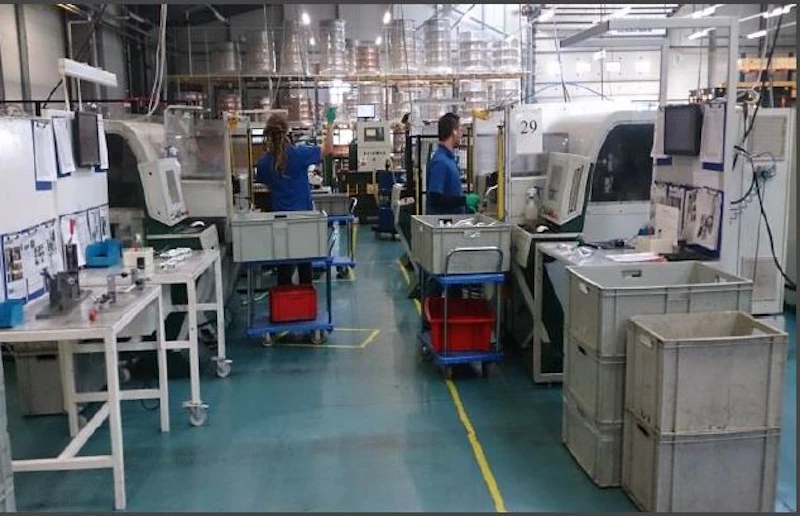A photo of the production cell layout implemented as a result of project and people working at the company.