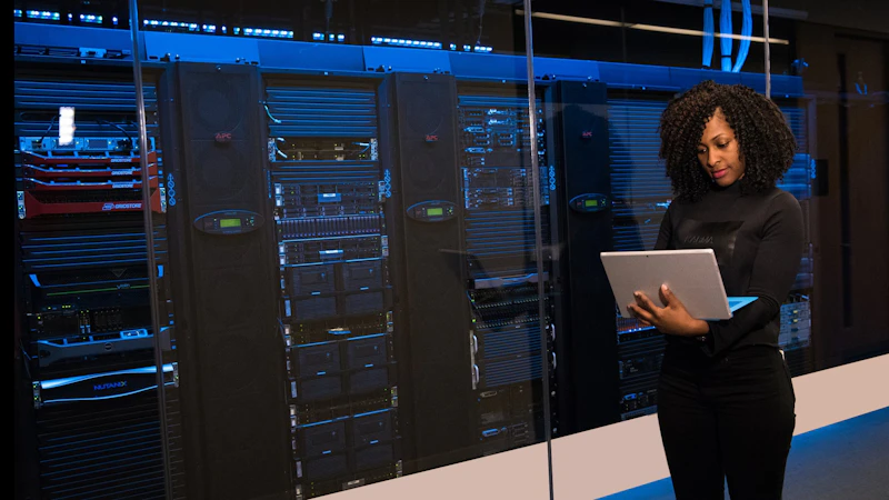 Woman at supercomputer holding a laptop