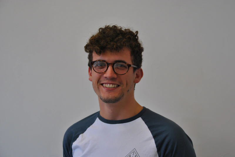 Jac Larner profile picture. Jac is in his 20's and wears glasses.