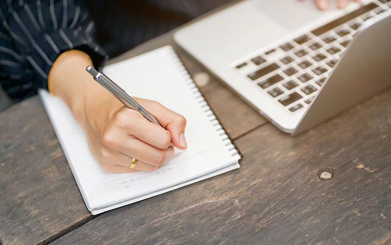 Delegate writing and working on laptop