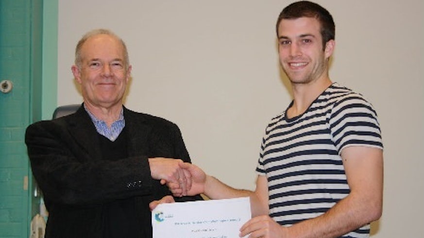 Two men shaking hands and holding a certificate. 