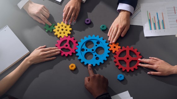 Teamwork of businesspeople work together and combine pieces of gears stock image