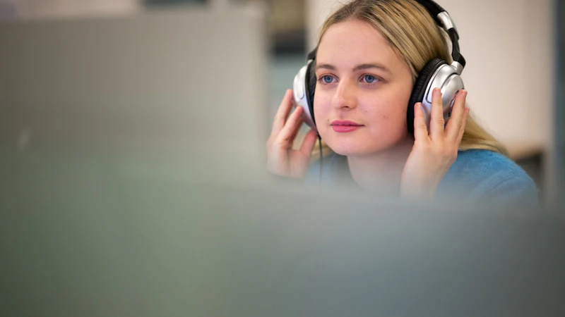Image of a student in front of a Mac desktop