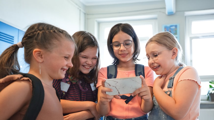 School girls using smart phone together