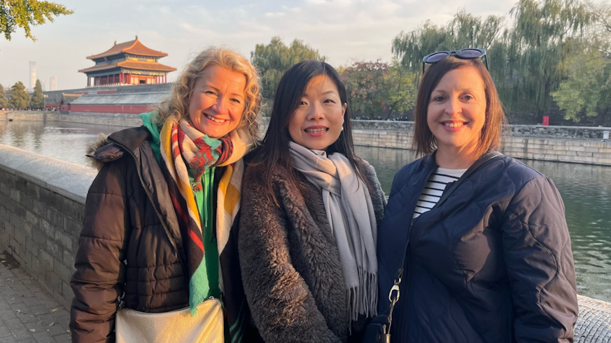 Sarah, Jane and Eleri stood by a lake with a traditional Chinese building in the background.