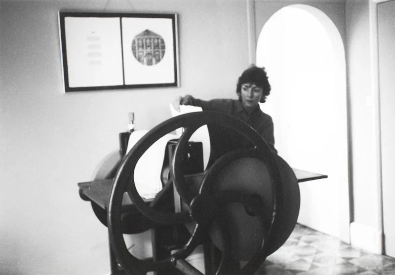 A woman works with a printing press