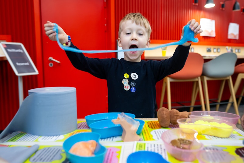 A young boy playing with slime.