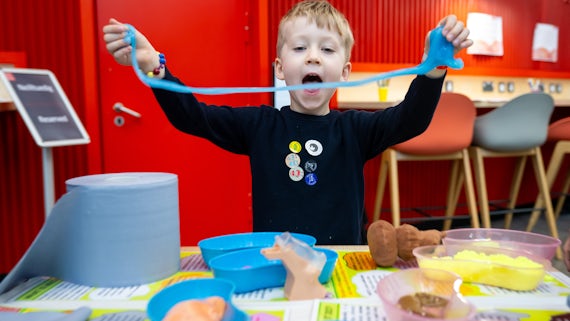 A young boy playing with slime.