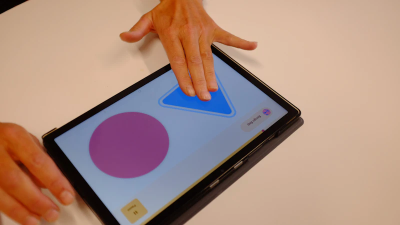 Participants gathered around a table using the DRUM app on a tablet.