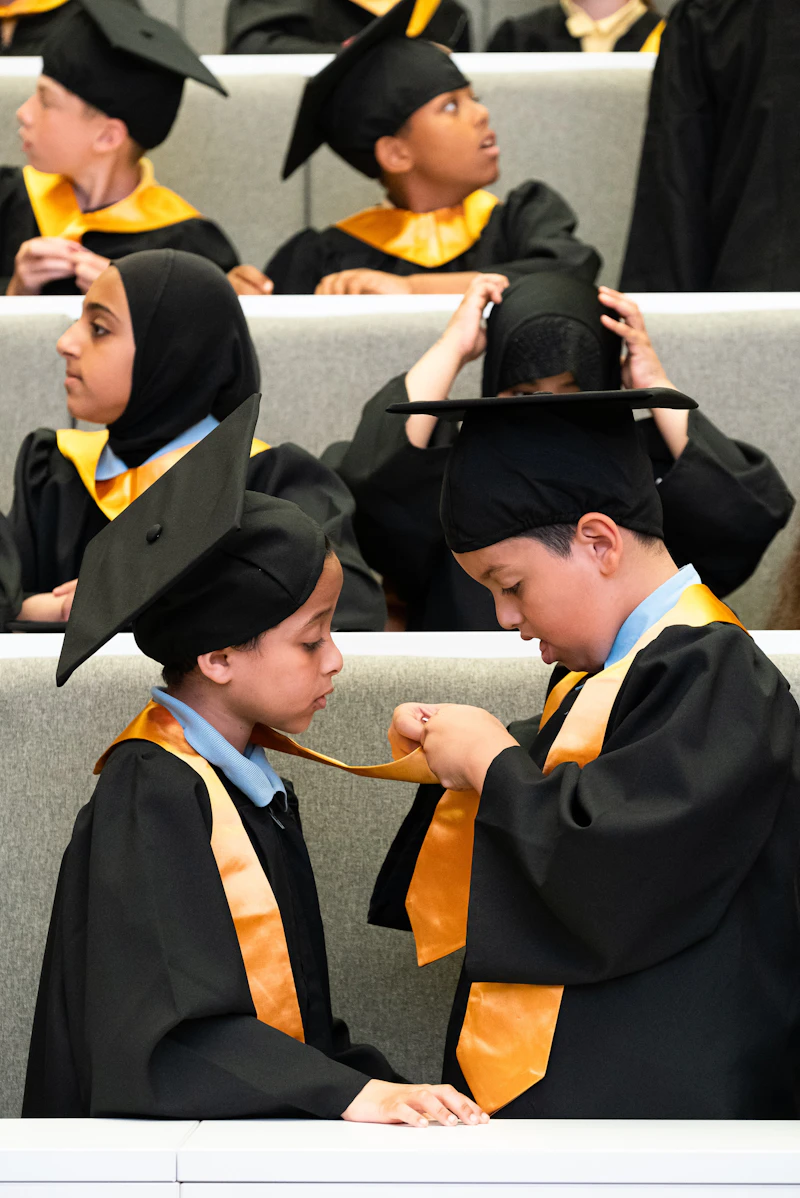 Two boys wearing graduation gowns