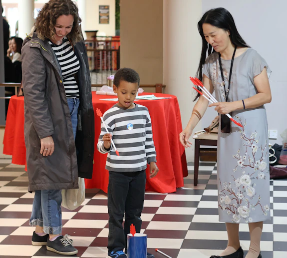 Mother and son try the tossing sticks game