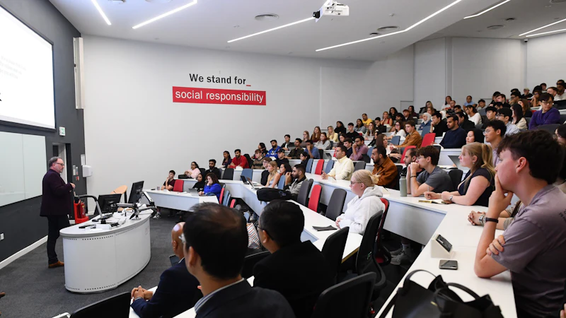 View from the corner of a lecture theatre of speaker and the audience.