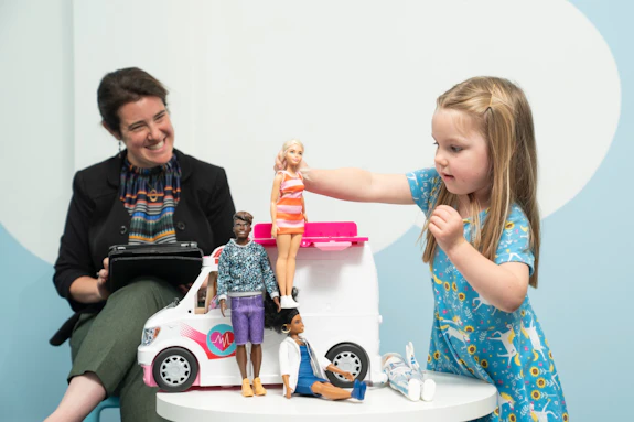 Dr Sarah Gerson observing a girl playing with barbies and a barbie car