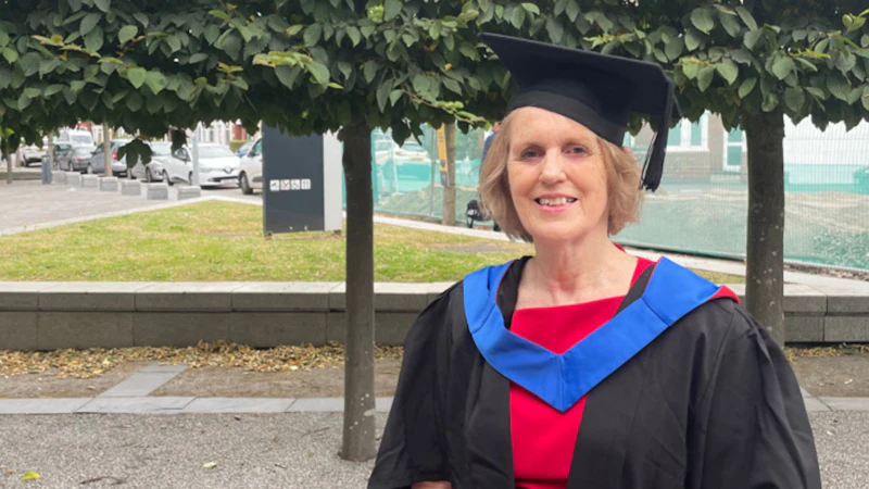 A lady in her graduation gown and cap.