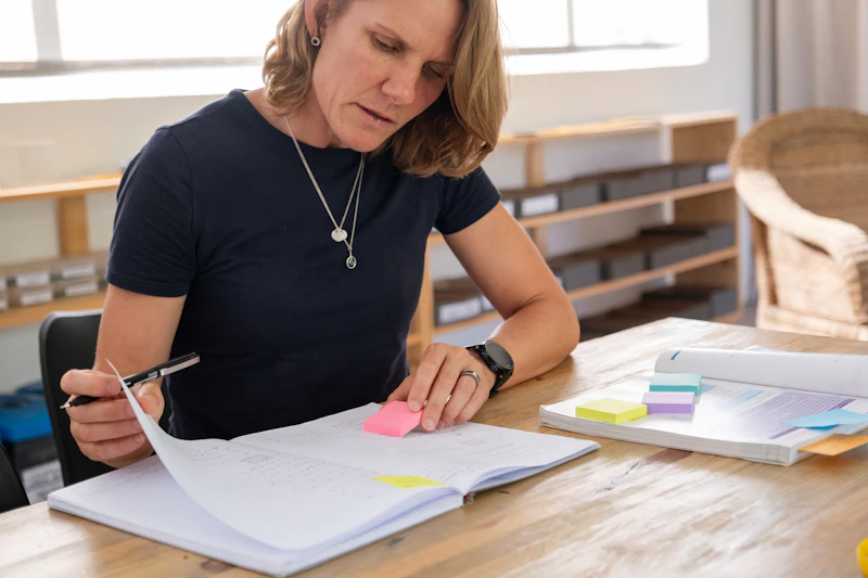 Female academic sitting at a desk marking papers