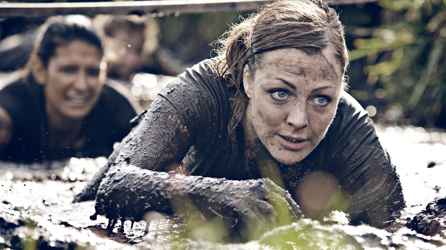 Women crawling through mud on course