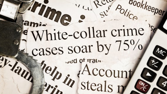 Handcuffs and calculator on headlines about white collar crime