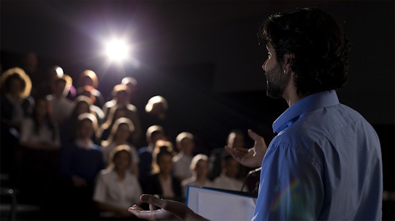 A man speaks to a small audience