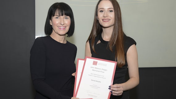 Two women pose with certificates