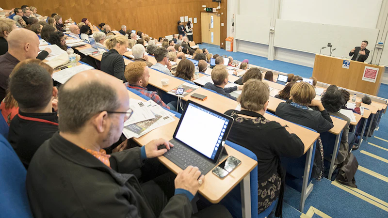 A full lecture theatre watch a speaker from 2017’s conference