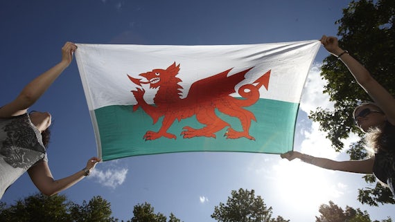 Welsh flag behind held by two people