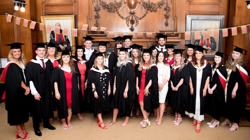 Group image of male and female students in their graduation gowns