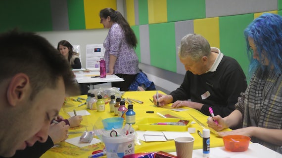 The workshop involved using creative materials to contribute to an artwork.