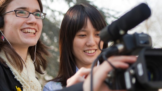 Two female student journalists using film equipment