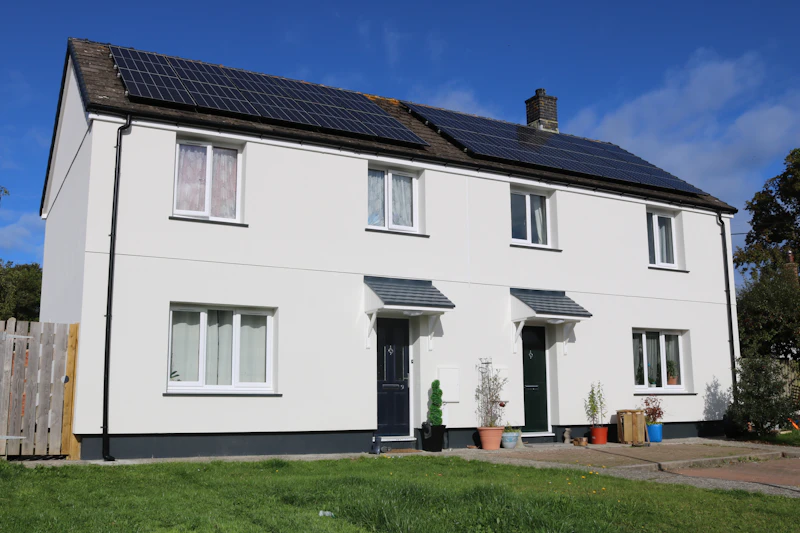 Semi-detached social housing retrofitted with solar panels, insulation, battery storage, ventilation and an air source heat pump.