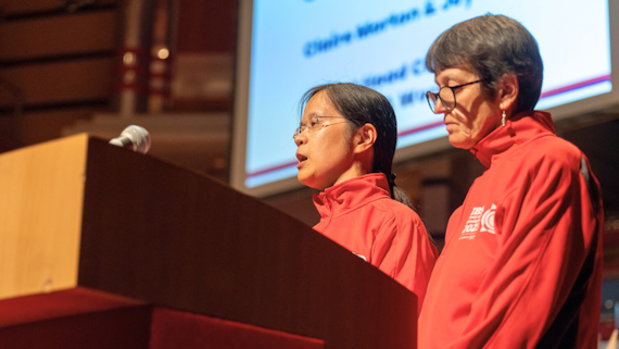 Professor Joy Myint from the school of Optometry at the Blind Games standing at a podium with a colleague
