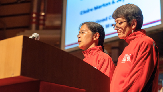 Professor Joy Myint from the school of Optometry at the Blind Games standing at a podium with a colleague