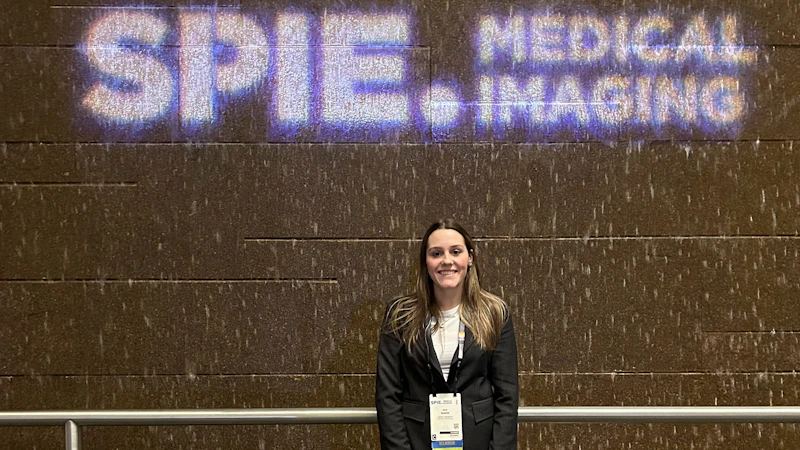 Faye Warren smiling and holding her SPIE conference award