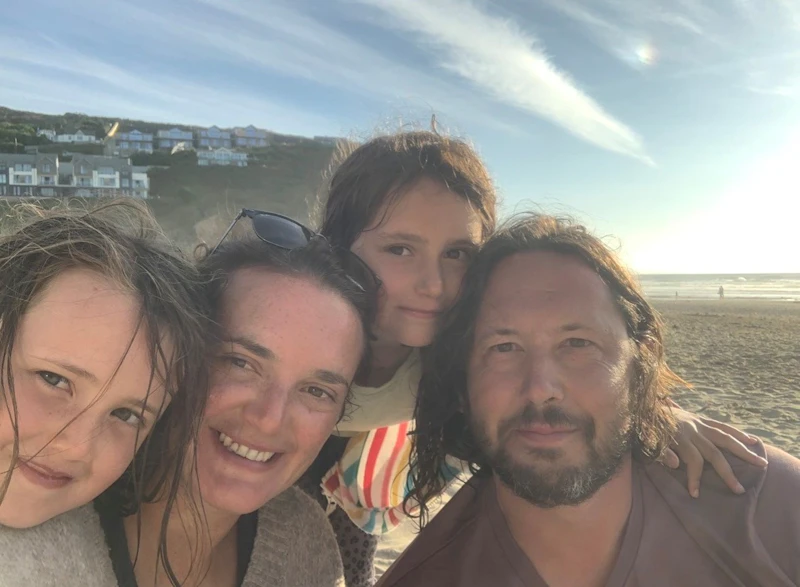 Deb Lewis, her husband Phil and two of their children on a beach