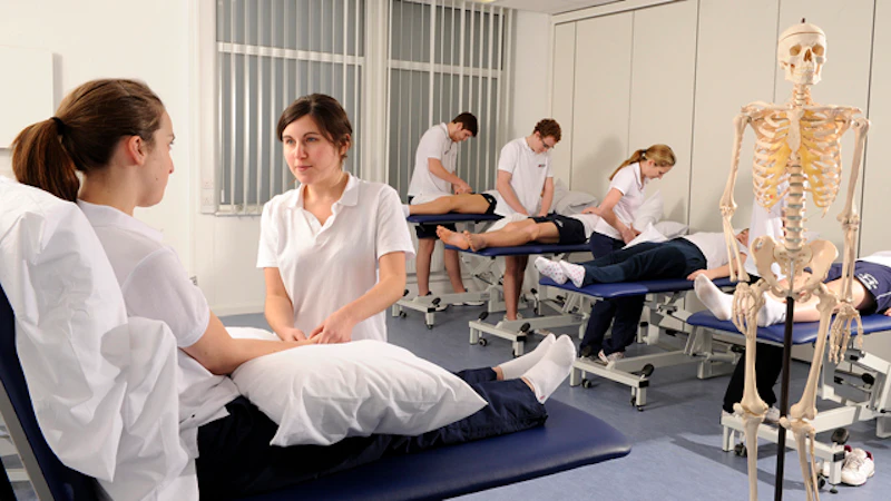 Students learning how to perform a massage